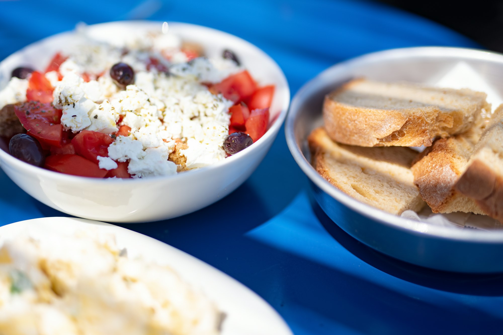 Greek taverna spread — feta, olives, salad, bread